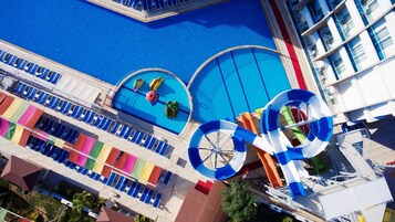 Uma área de piscina com vários toboáguas e espreguiçadeiras.