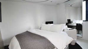 A modern hotel room with a large bed, a desk, and a chair. - Circle Hotel Seoul (Seoul)