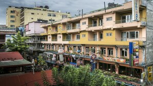 A multi-story hotel with balconies, a pub, and various shops on the ground floor. - The Nana Hotels (Kathmandu)