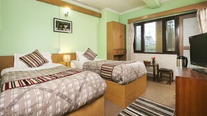 A hotel room with two beds, a desk, a television, and a window with curtains. - The Nana Hotels (Kathmandu)