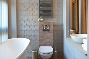 A modern bathroom with a large freestanding bathtub, a toilet, and a sink. - La Gioia Grey Stylish Apartments (Kraków)