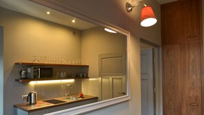 A modern kitchen with a microwave, kettle, and sink.