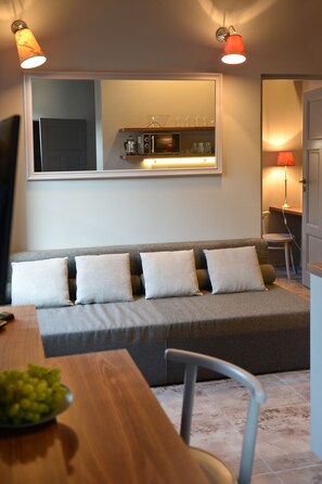 Relax in this stylish living space with a sofa, dining table, and kitchen area.