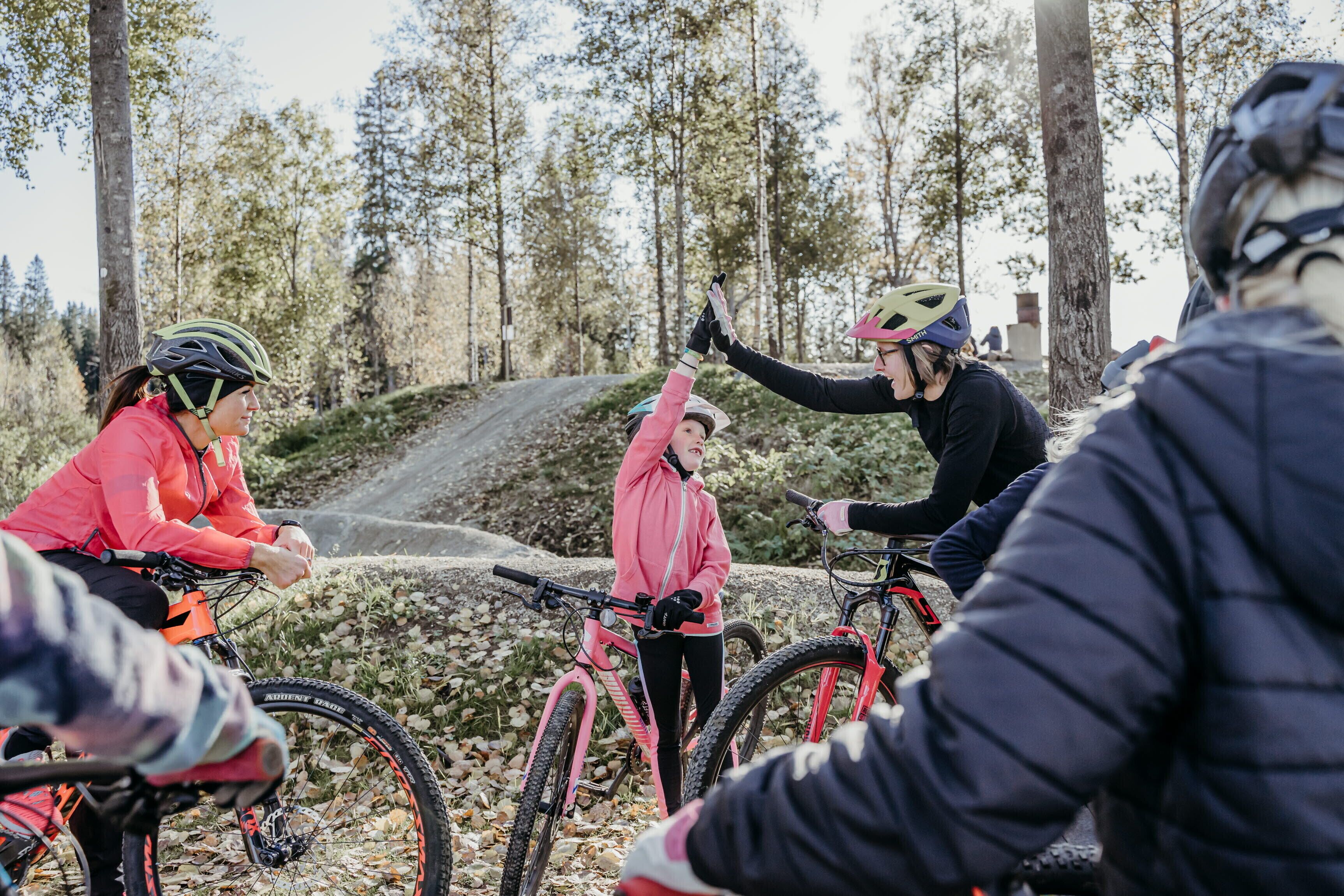 En gruppe mennesker cykler i et skovområde.