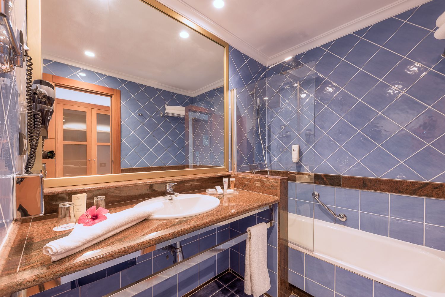 Une salle de bain avec un lavabo, un miroir et un espace douche.