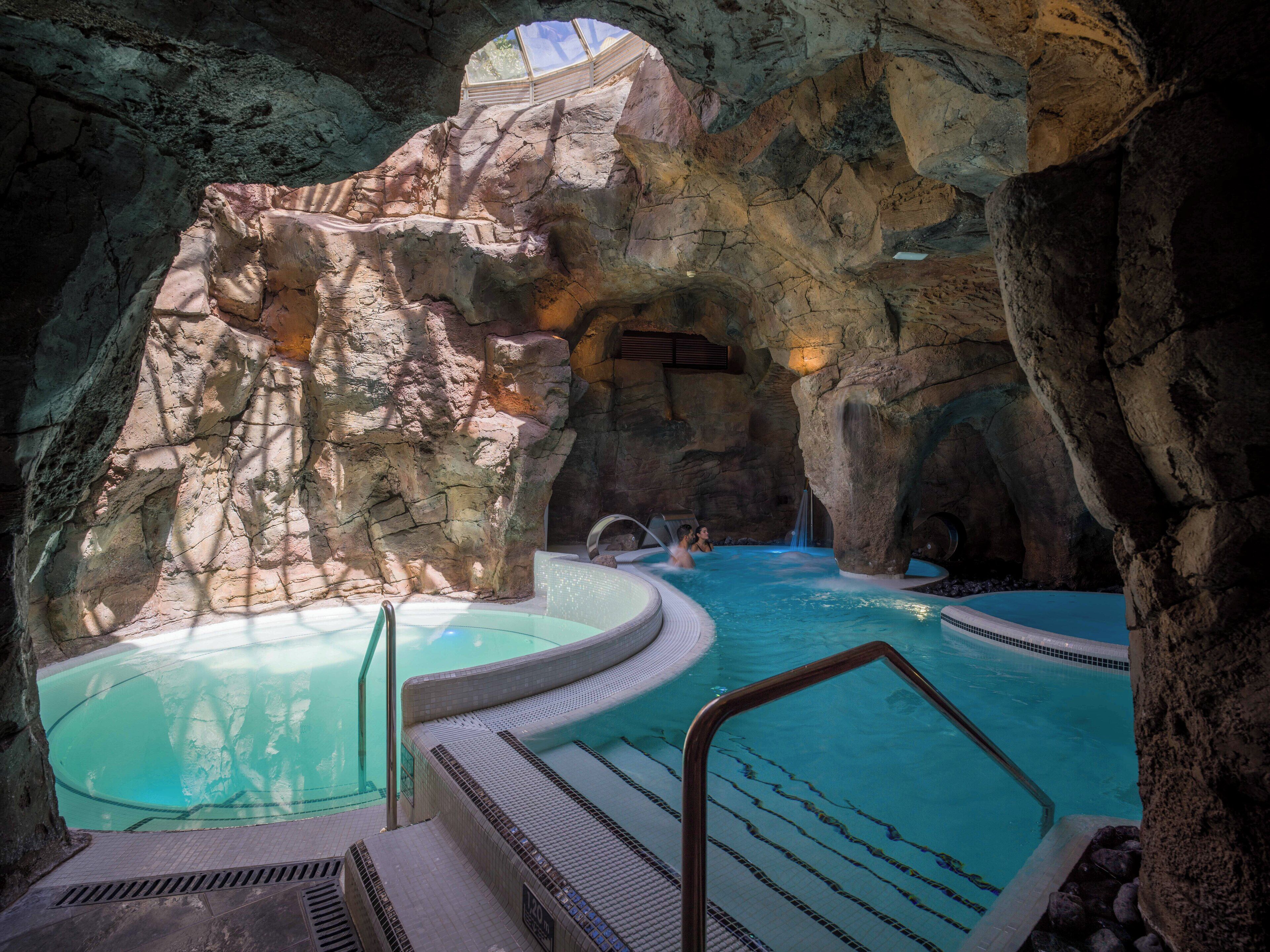 Et naturligt klippeformation omgiver et område med jacuzzi.