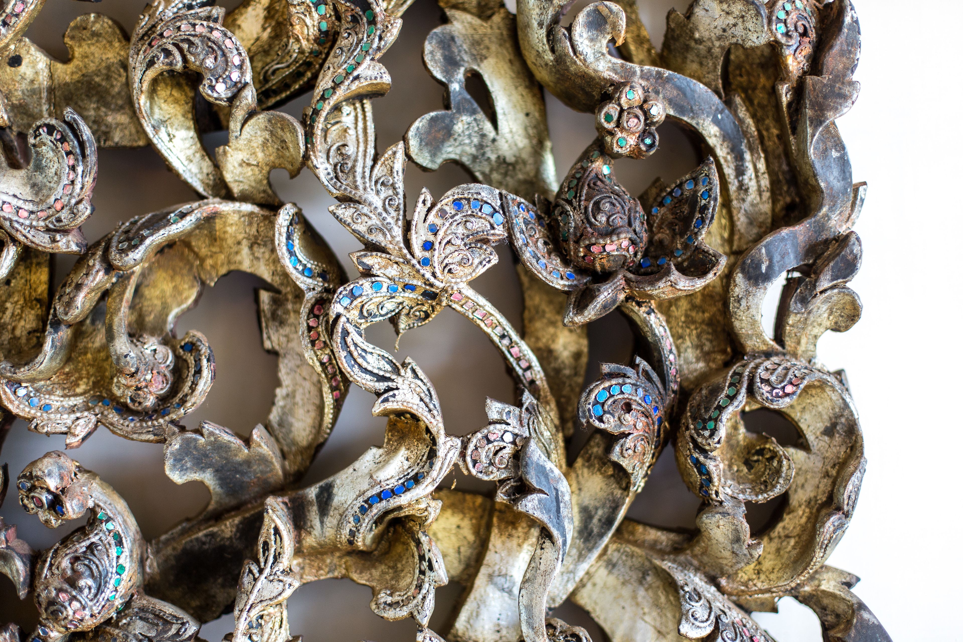 A close-up of ornate metalwork with intricate designs and embedded gemstones.
