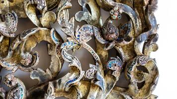 A close-up of ornate metalwork with intricate designs and embedded gemstones.