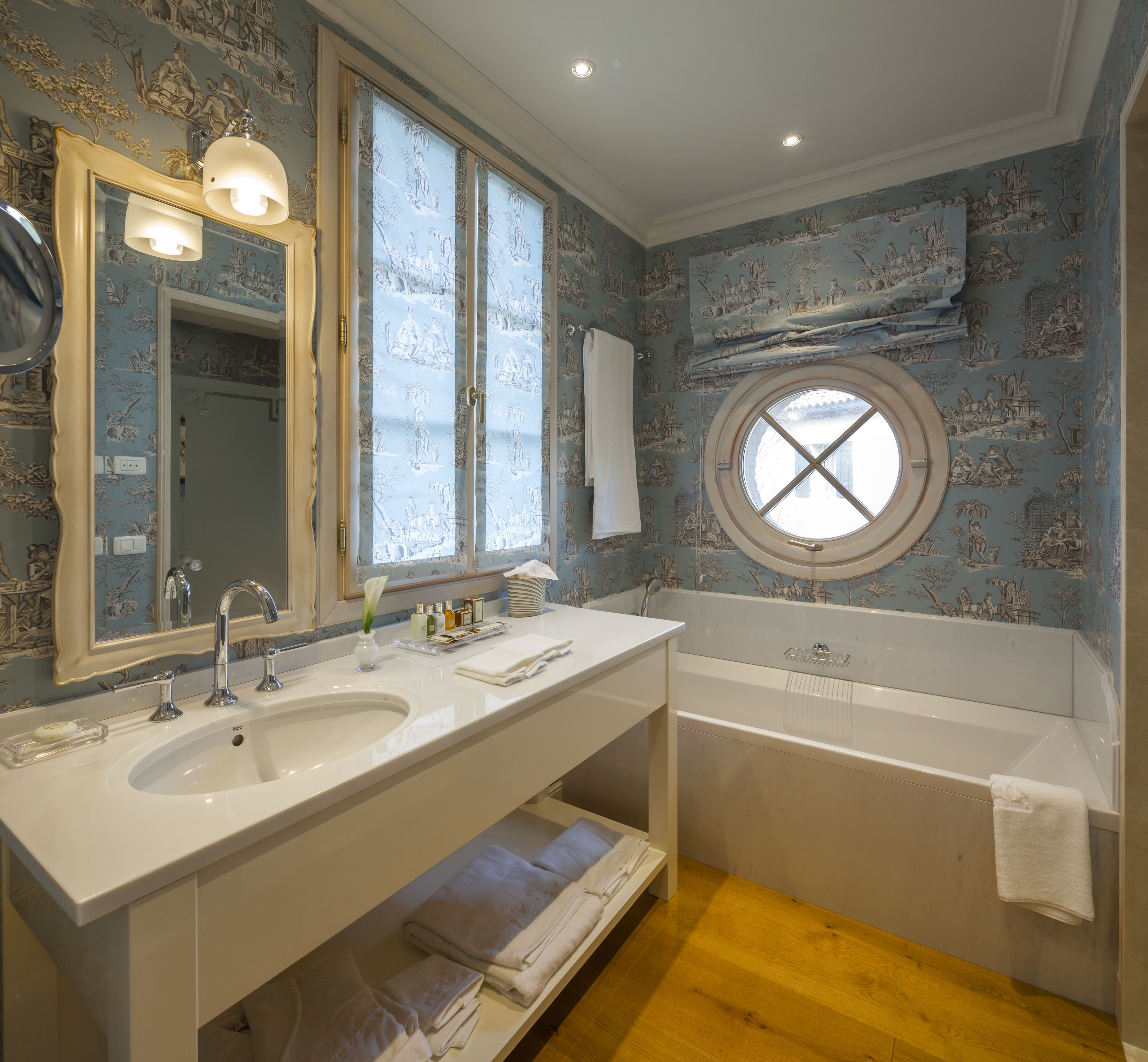 Une salle de bain avec deux lavabos, un grand miroir et une baignoire.