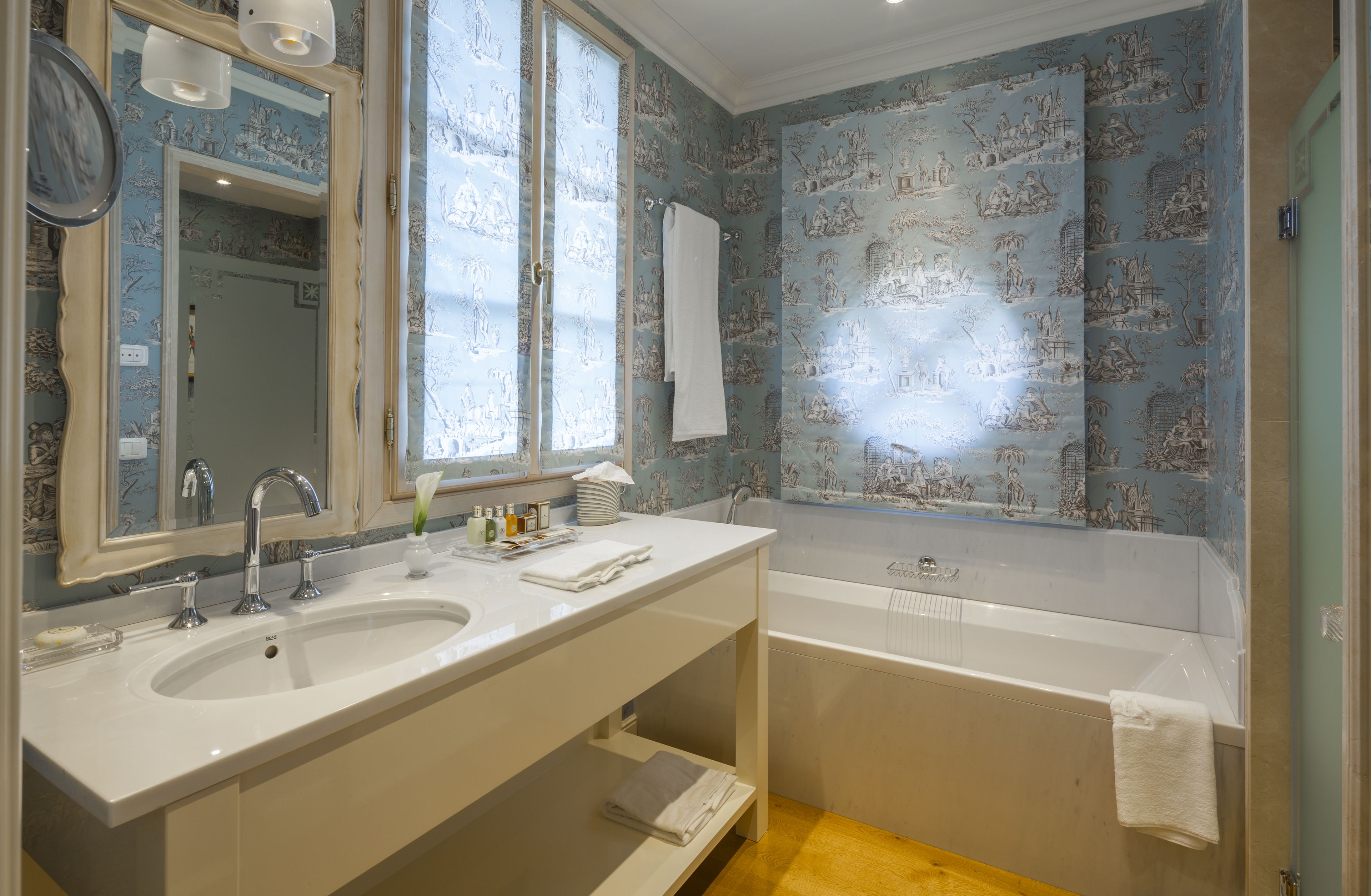 Ein Badezimmer mit zwei Waschbecken, einer Badewanne und einem Spiegel.