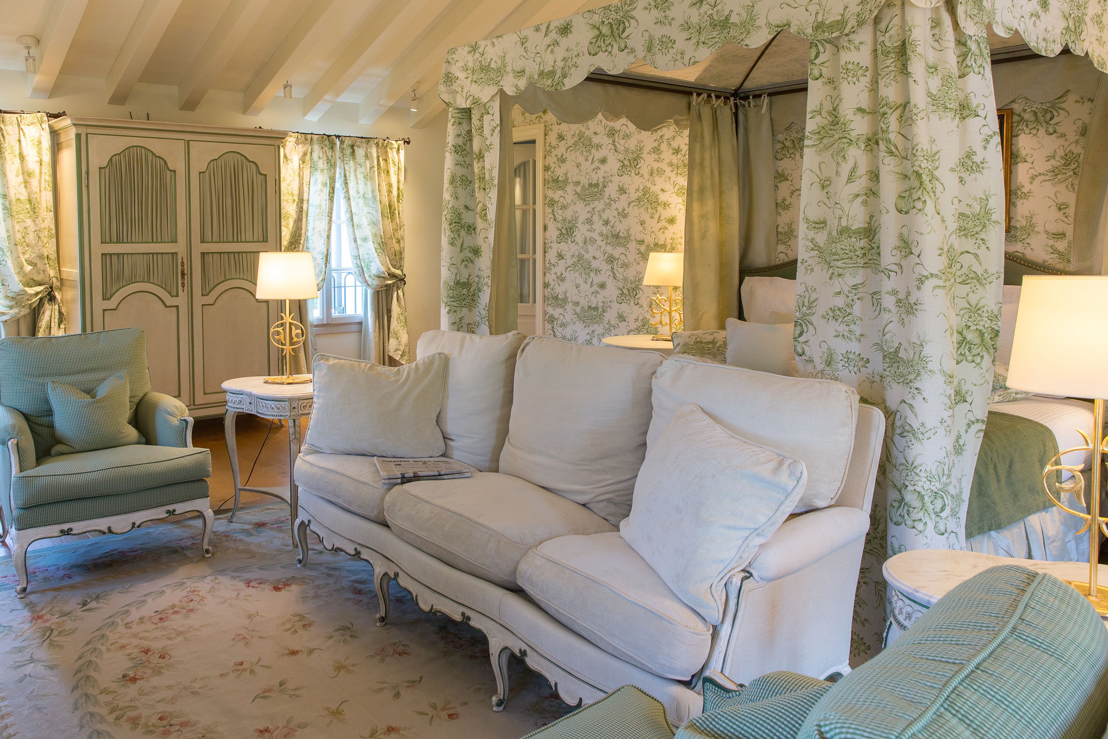 A vintage-style living room with a sofa, armchairs, and a small table.