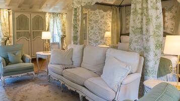 A vintage-style living room with a sofa, armchairs, and a small table.