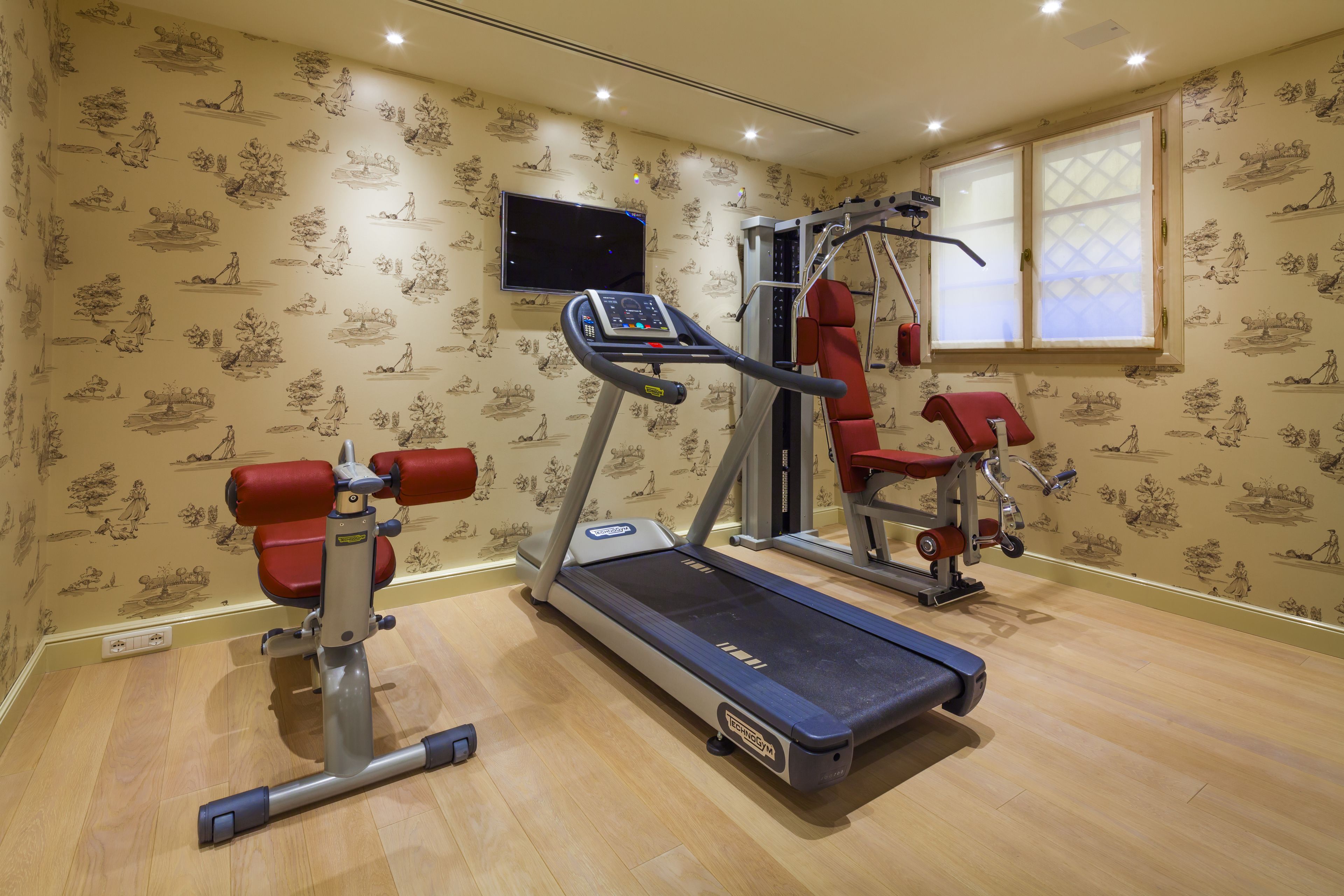 A home gym with a treadmill, weight bench, and exercise machine.