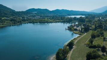An aerial view of a lake surrounded by hills, with a small dock and a few buildings near the shore.