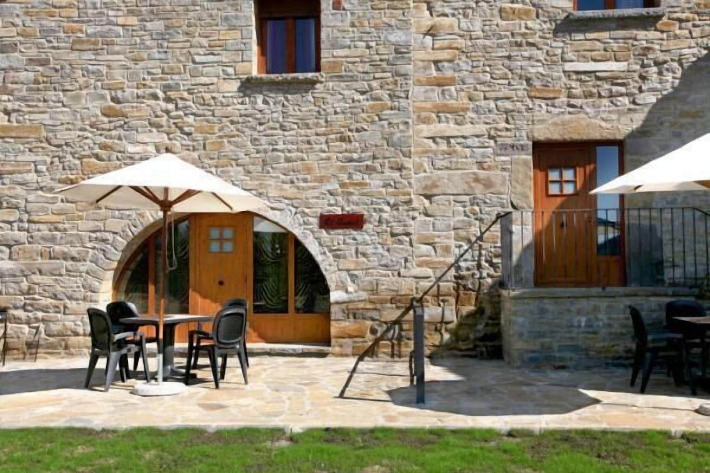 A stone building with outdoor seating and a staircase.