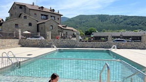 Una piscina con edificios de piedra al fondo.