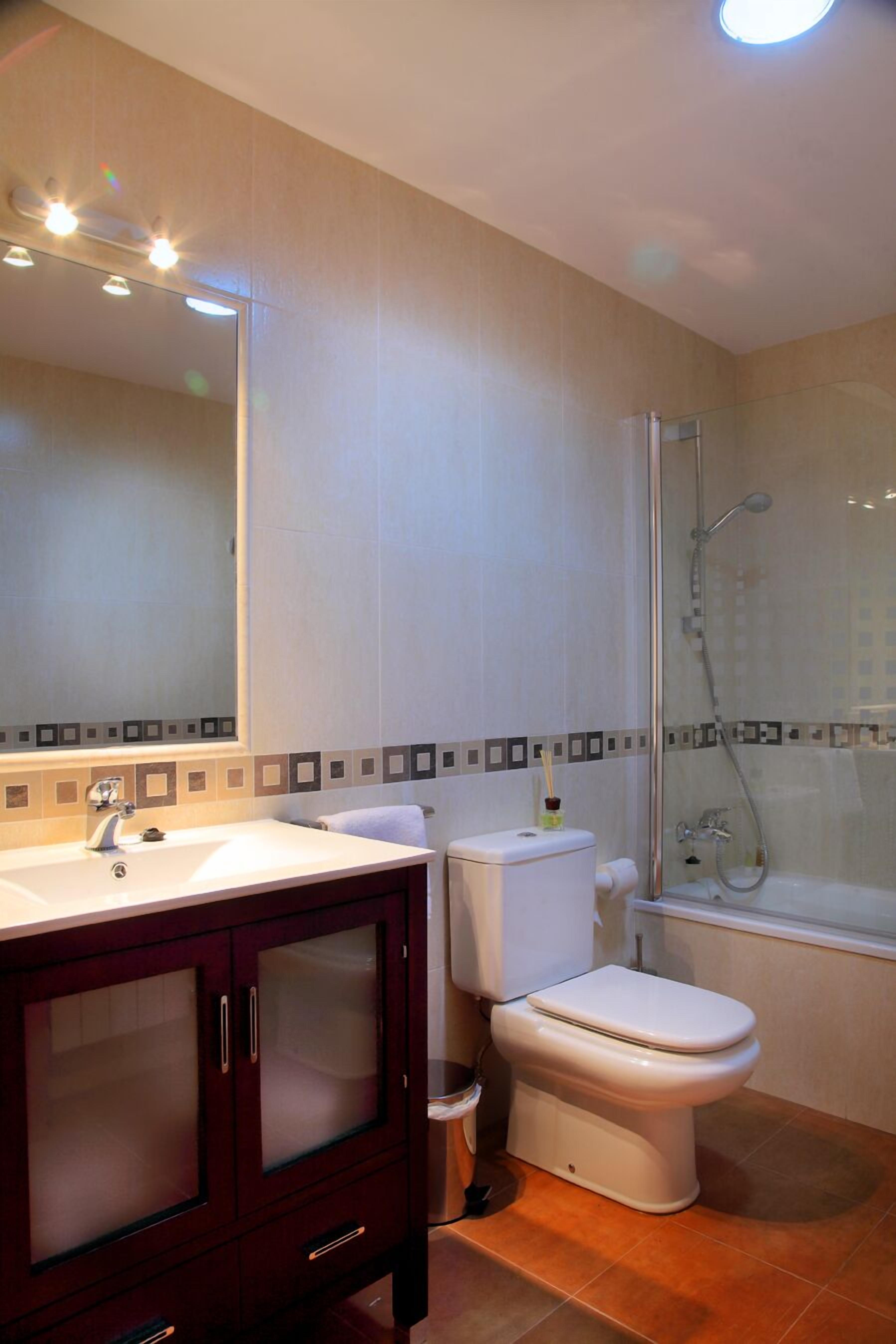 A bathroom with a toilet, sink, and shower.