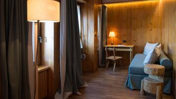 Une pièce chaleureuse avec des murs en bois, un canapé bleu, une petite table en bois et une lampe.