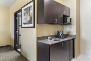 A compact kitchen with a microwave, sink, and dark cabinets. - Holiday Inn Express & Suites Anaheim Resort Area by IHG (Anaheim)