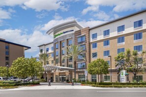 A Holiday Inn Express & Suites hotel with a modern design, featuring a covered entrance and multiple floors. - Holiday Inn Express & Suites Anaheim Resort Area by IHG (Anaheim)