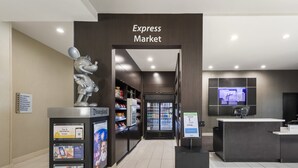 En moderne Express Market med en Mickey Mouse-statue, køleapparater og et digitalt skærmbillede.