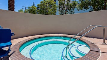 Una piscina al aire libre, sillones reclinables de piscina