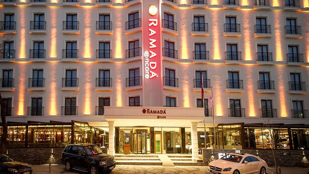 A multi-story hotel with a prominent vertical sign for Ramada.