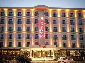 A multi-story hotel with a prominent vertical sign for Ramada.