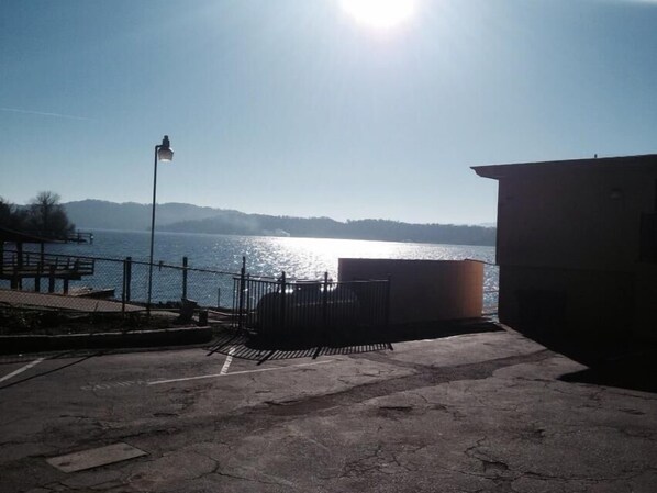 A waterfront area with a metal fence, a lamp post, and a building in the background.
