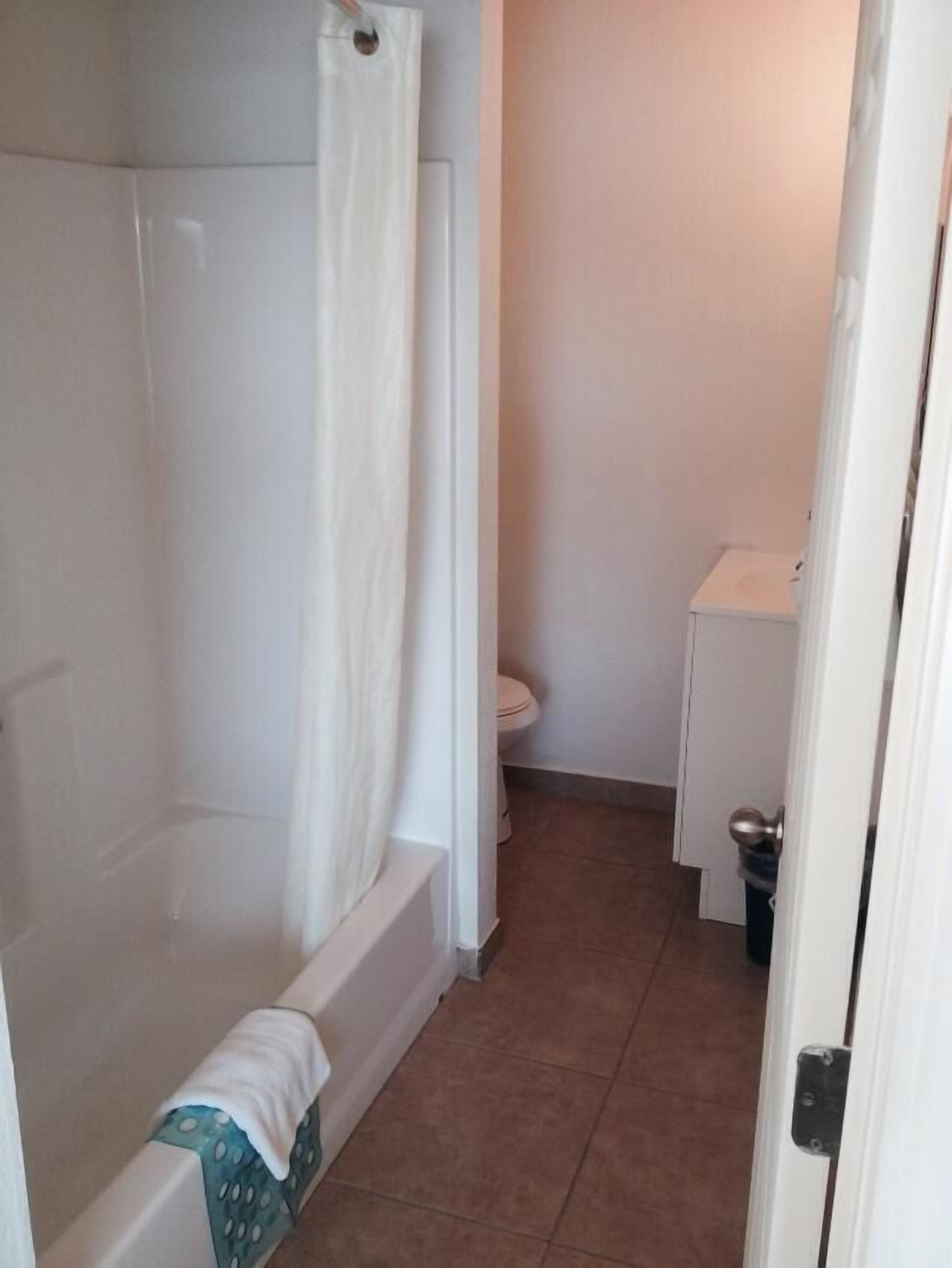 A bathroom with a bathtub, toilet, and sink.