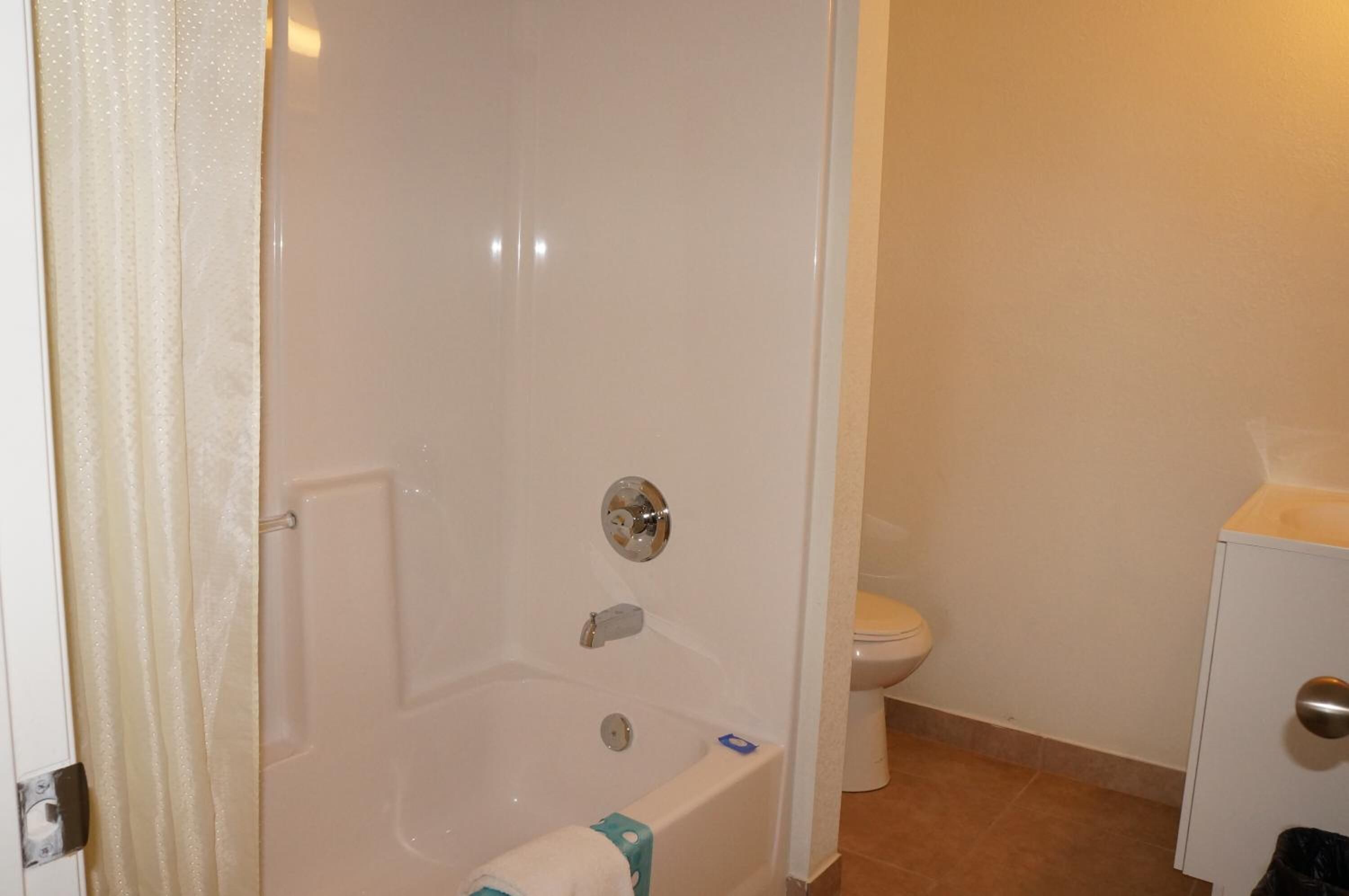 Un baño con bañera, inodoro y un armario.