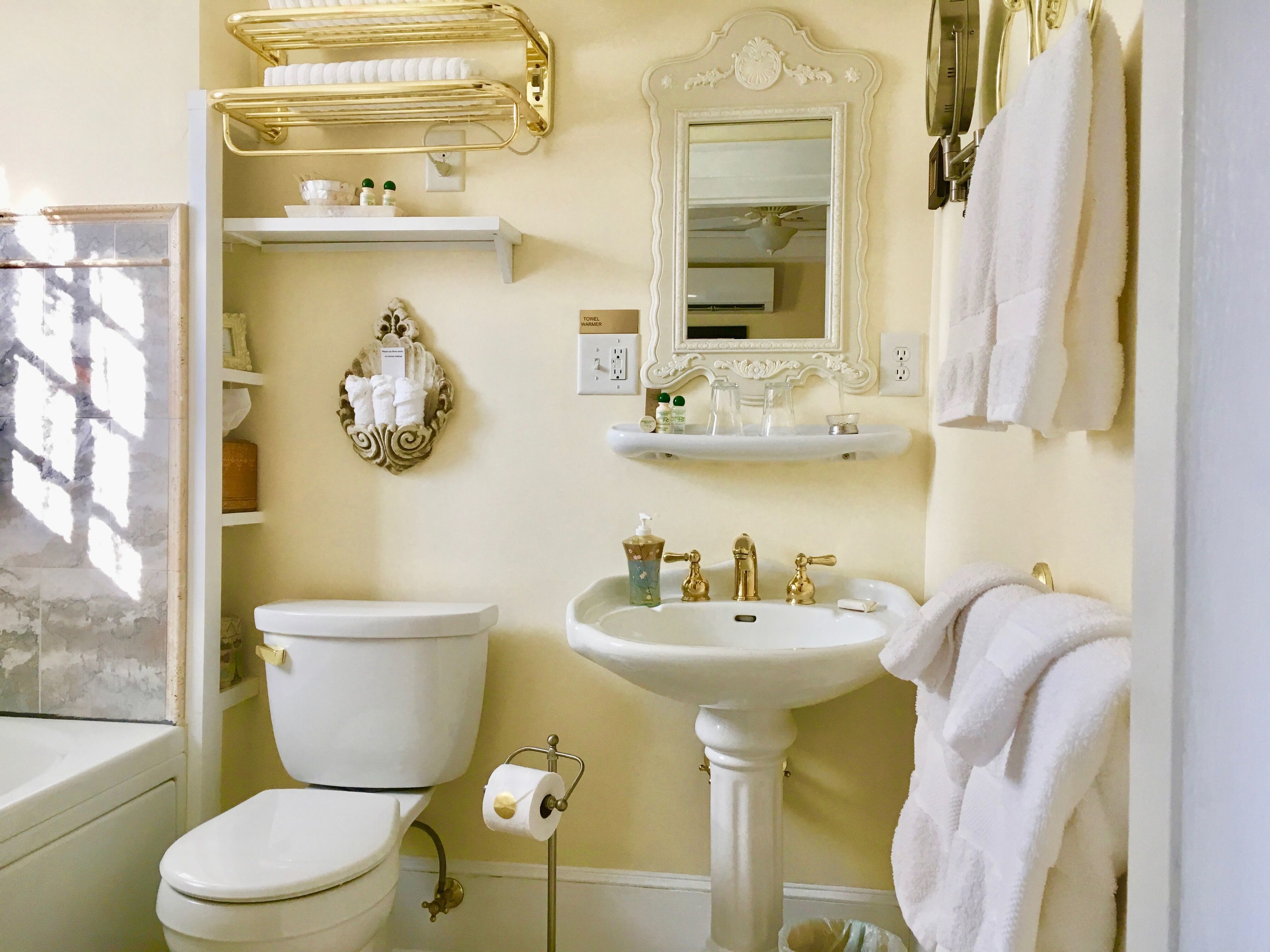 A bathroom with a toilet, sink, and towel rack.