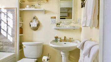A bathroom with a toilet, sink, and towel rack.