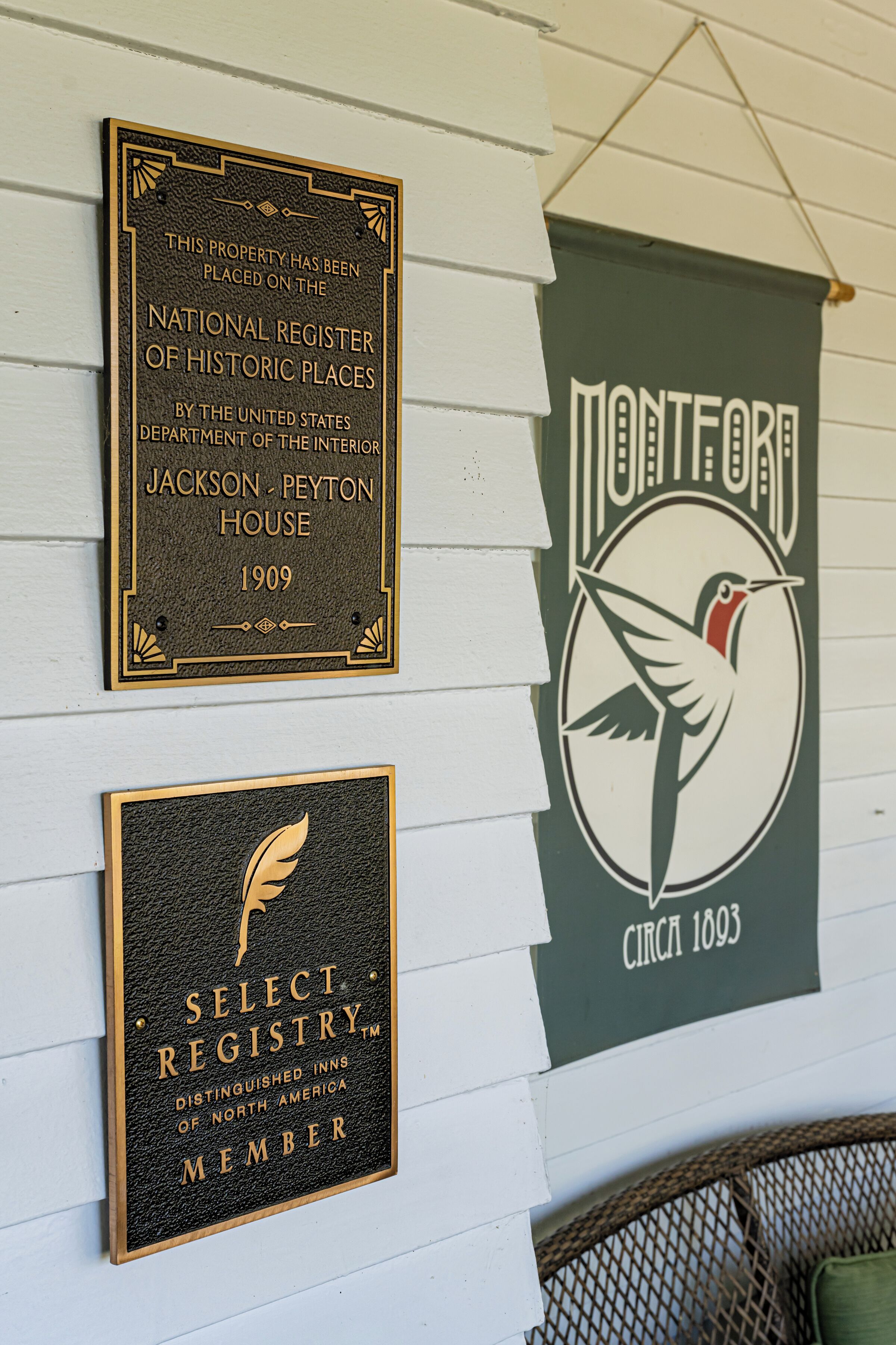 Tres placas en una pared: una para el Registro Nacional de Lugares Históricos, una para Select Registry y una para el Montfort Inn, construido alrededor de 1893.