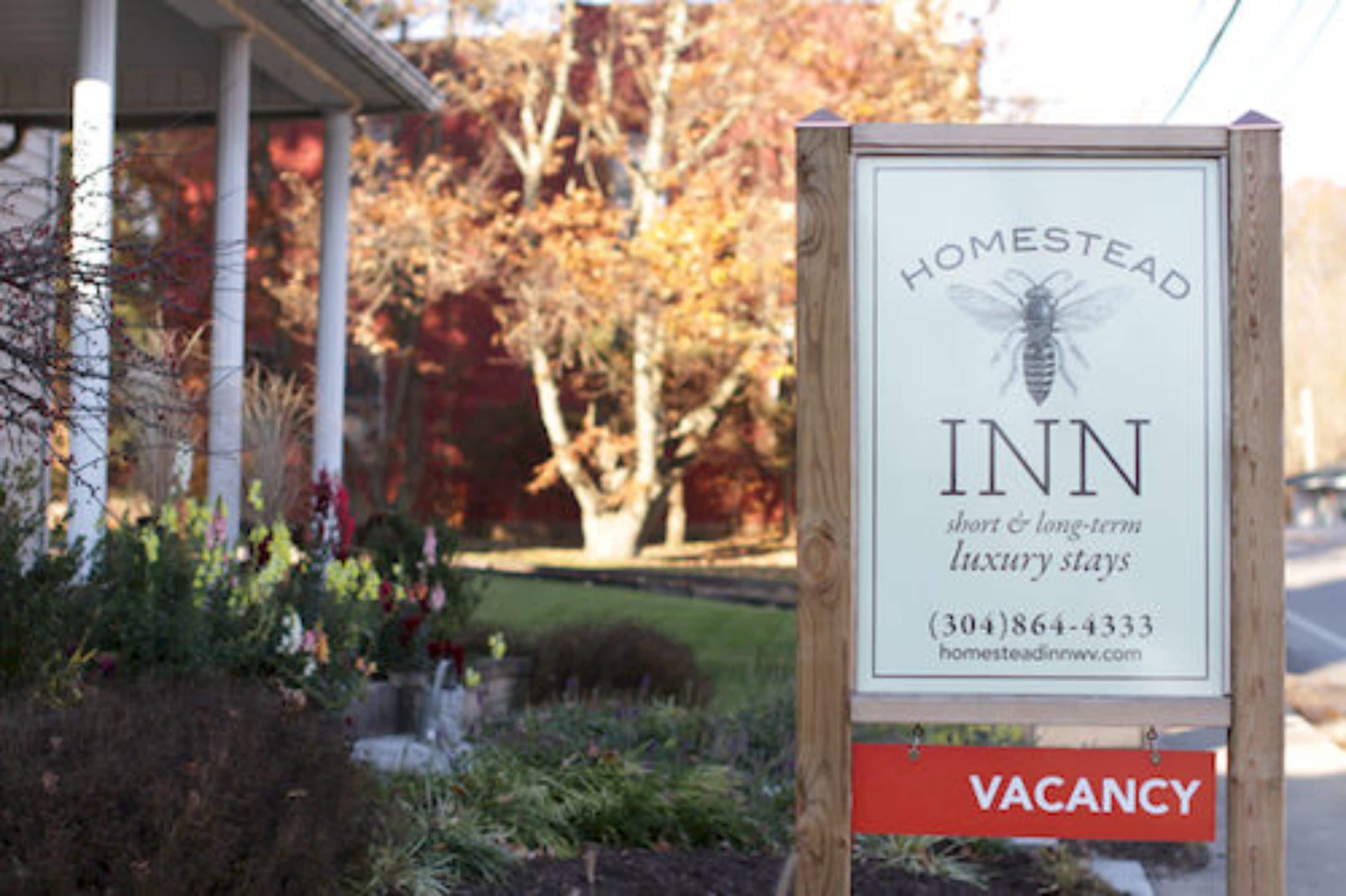 Homestead Inn -hotellin ulkopuolella oleva kyltti, jossa mainostetaan lyhyitä ja pitkiä, ylellisiksi suunniteltuja majoituksia.