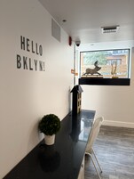 A modern interior with a black counter, a potted plant, and a window with a view of a building and a sculpture.