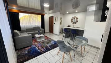 Habitación Deluxe, 1 cama King size | Área de sala de estar | Televisión