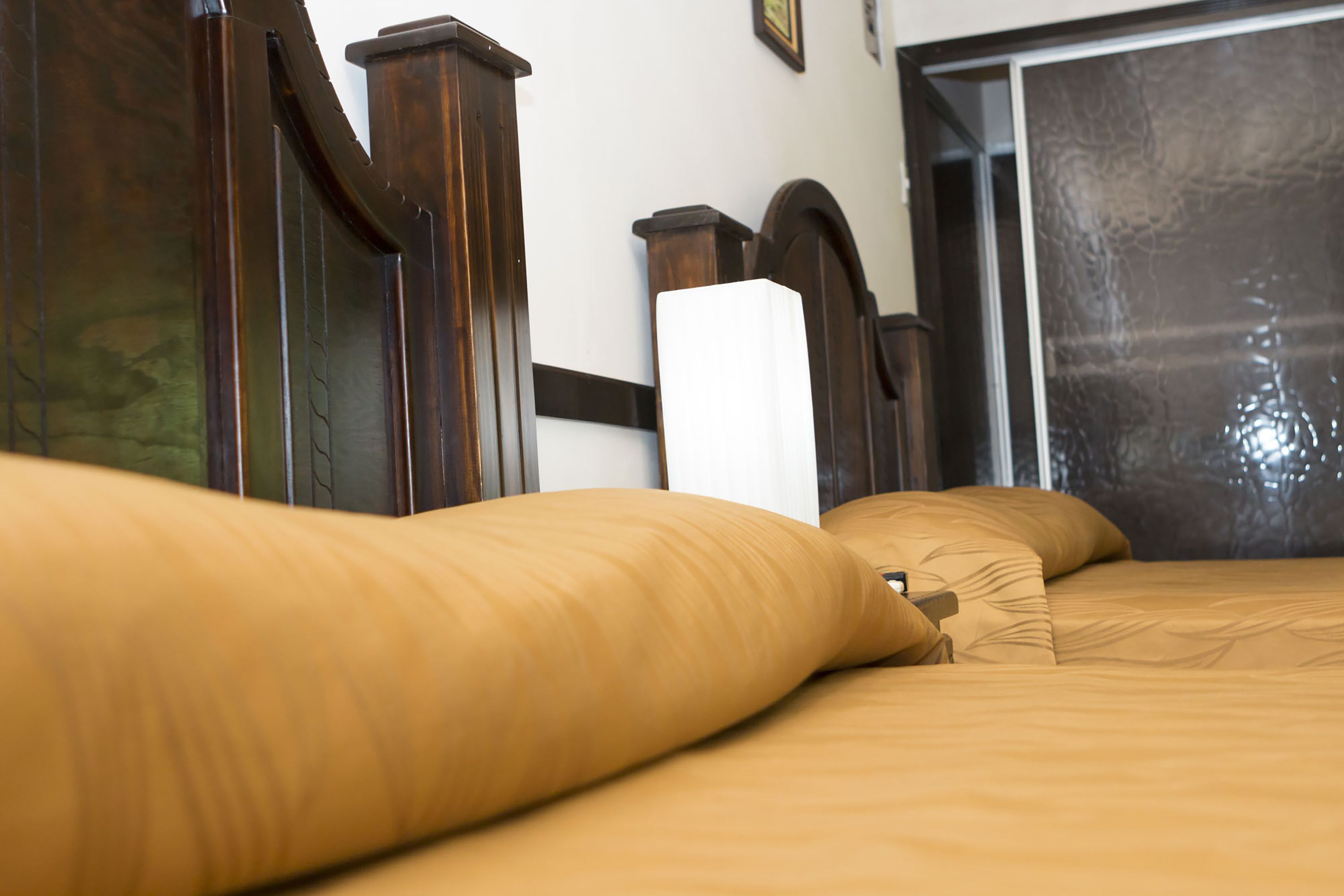 A bed with a wooden headboard and a white pillow.