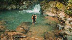A natural setting with a waterfall and clear water.