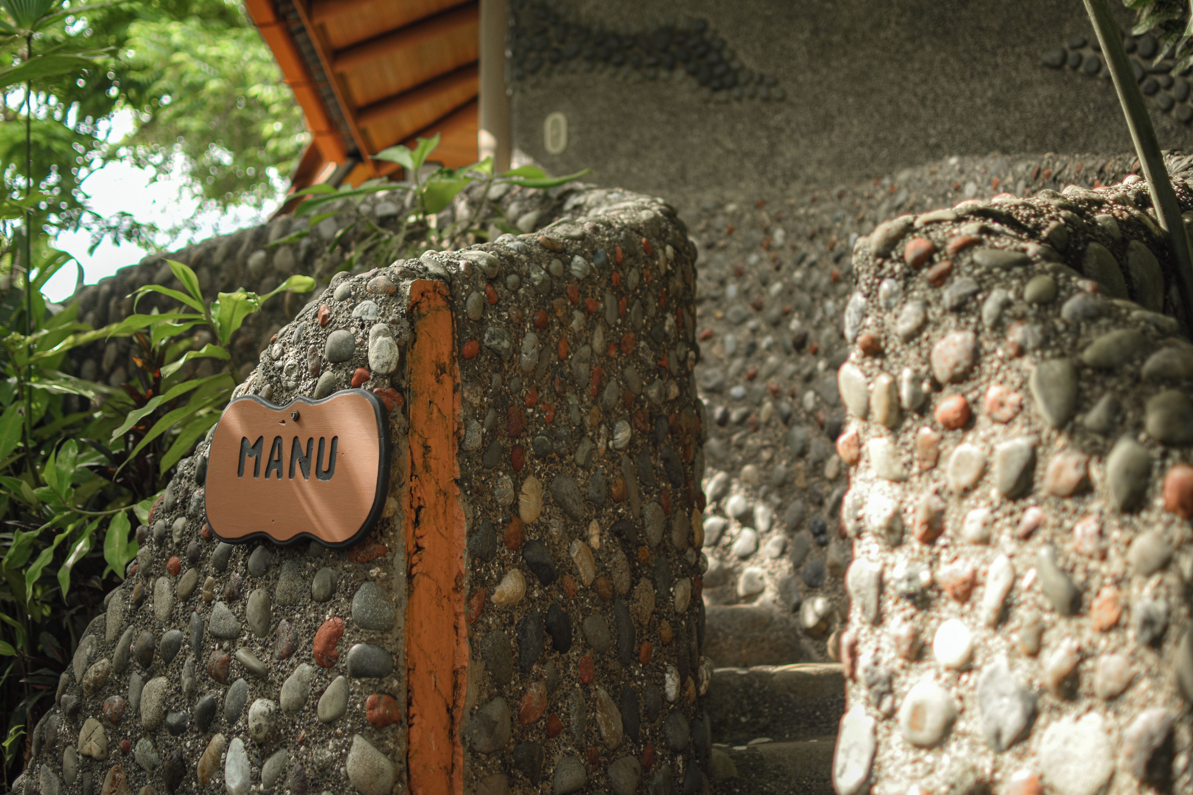 Un camino de piedra con un letrero que dice 'MANU'.