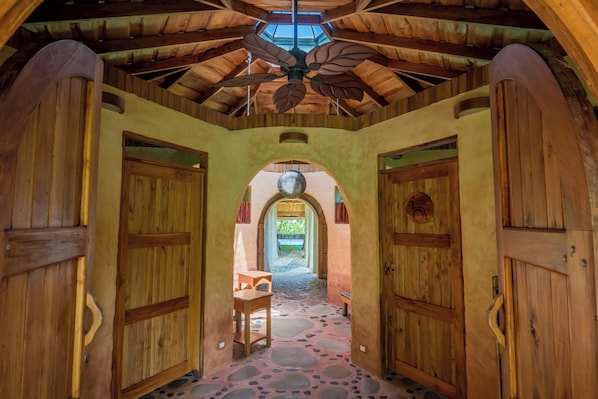 A wooden interior with a vaulted ceiling and a central chandelier.