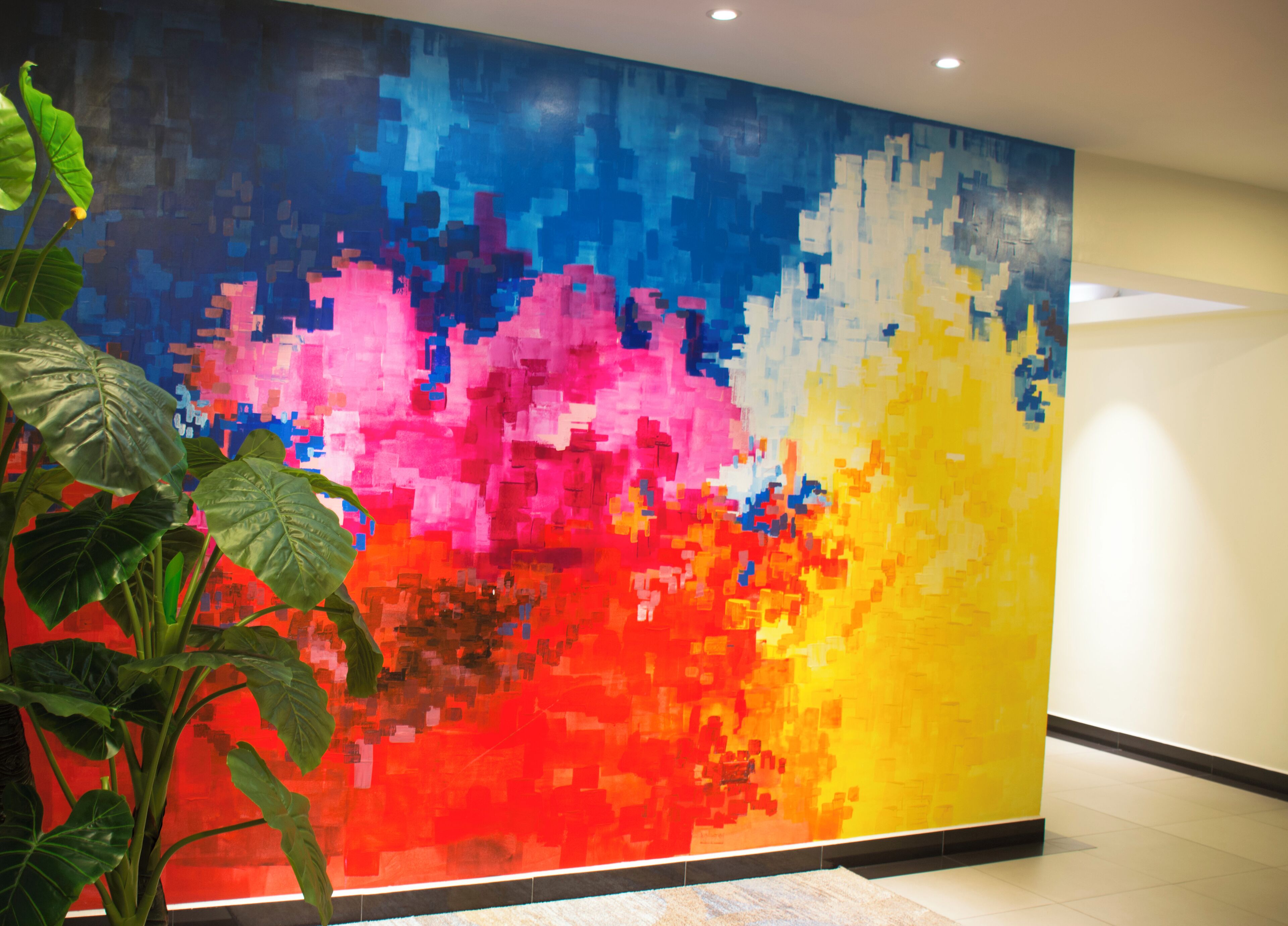 Une fresque murale colorée et pixelisée orne le hall d'entrée.