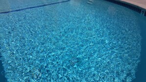 Une piscine aux eaux limpides et à la transparence remarquable, dont le bord est revêtu de carreaux.