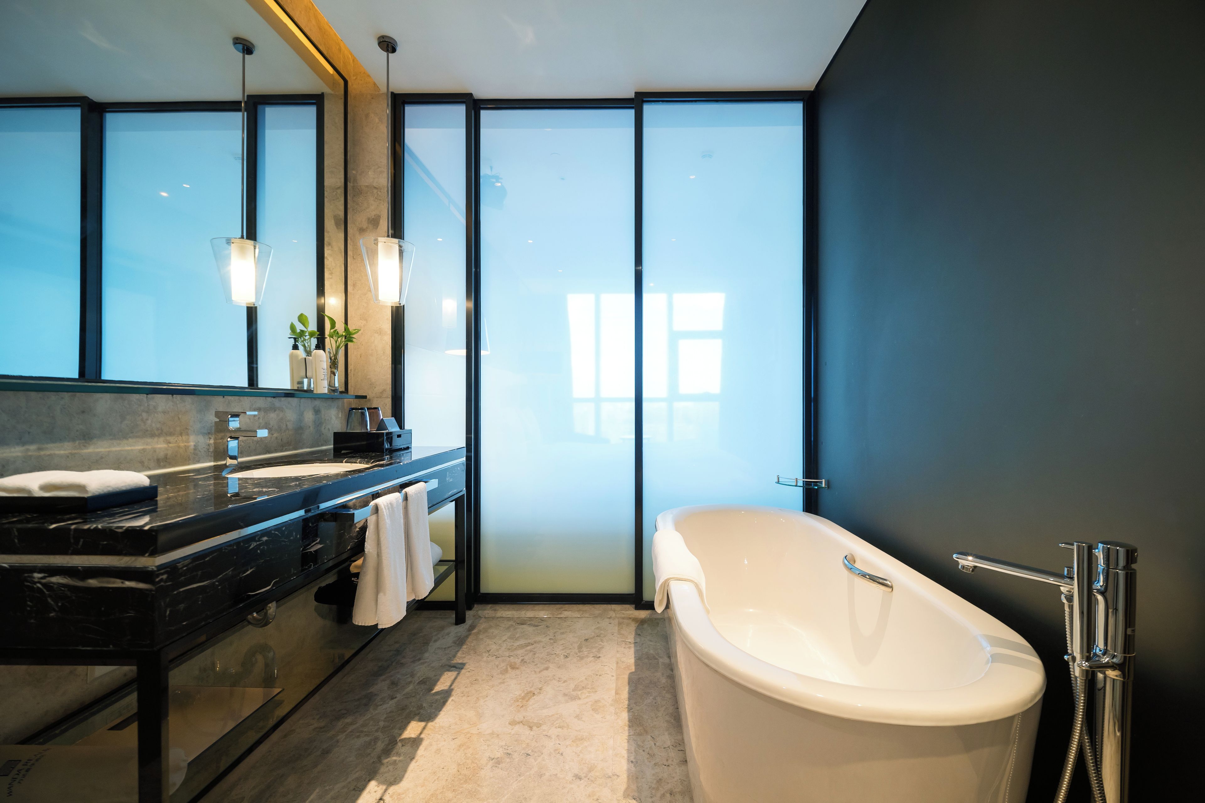 Une salle de bain moderne avec une grande baignoire, un meuble-lavabo avec un miroir et une cabine de douche en verre.