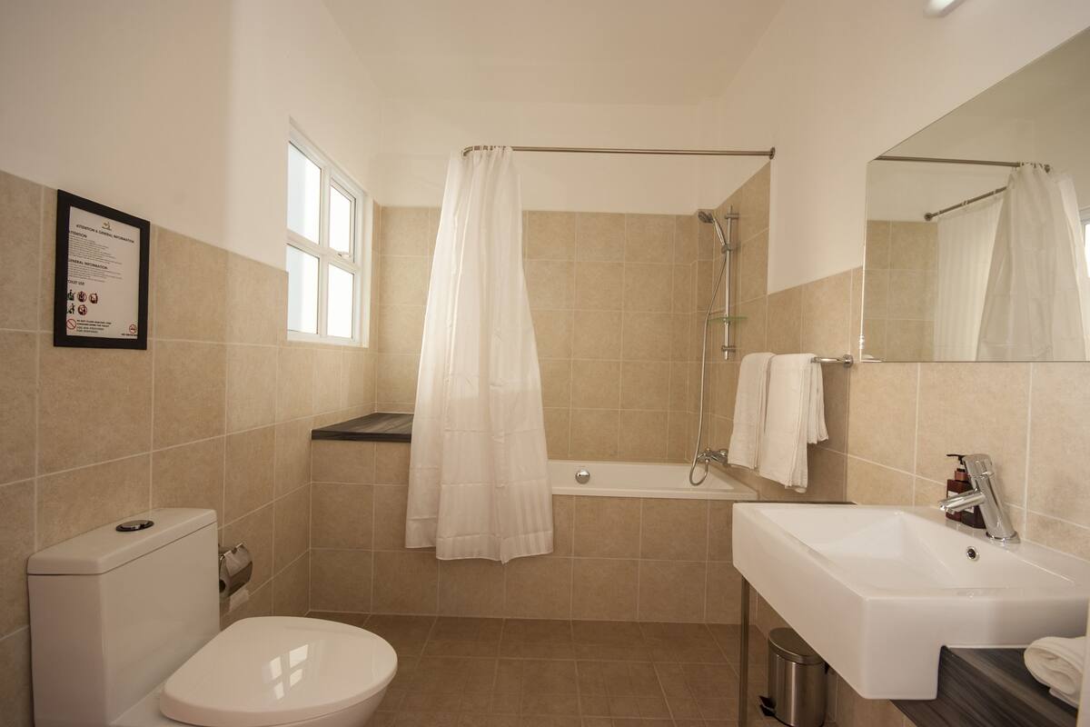 Tina y regadera independientes y amenidades de baño gratuitas