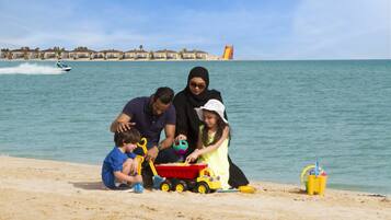 Enjoy beach activities and water sports nearby, with a lifeguard tower in sight.