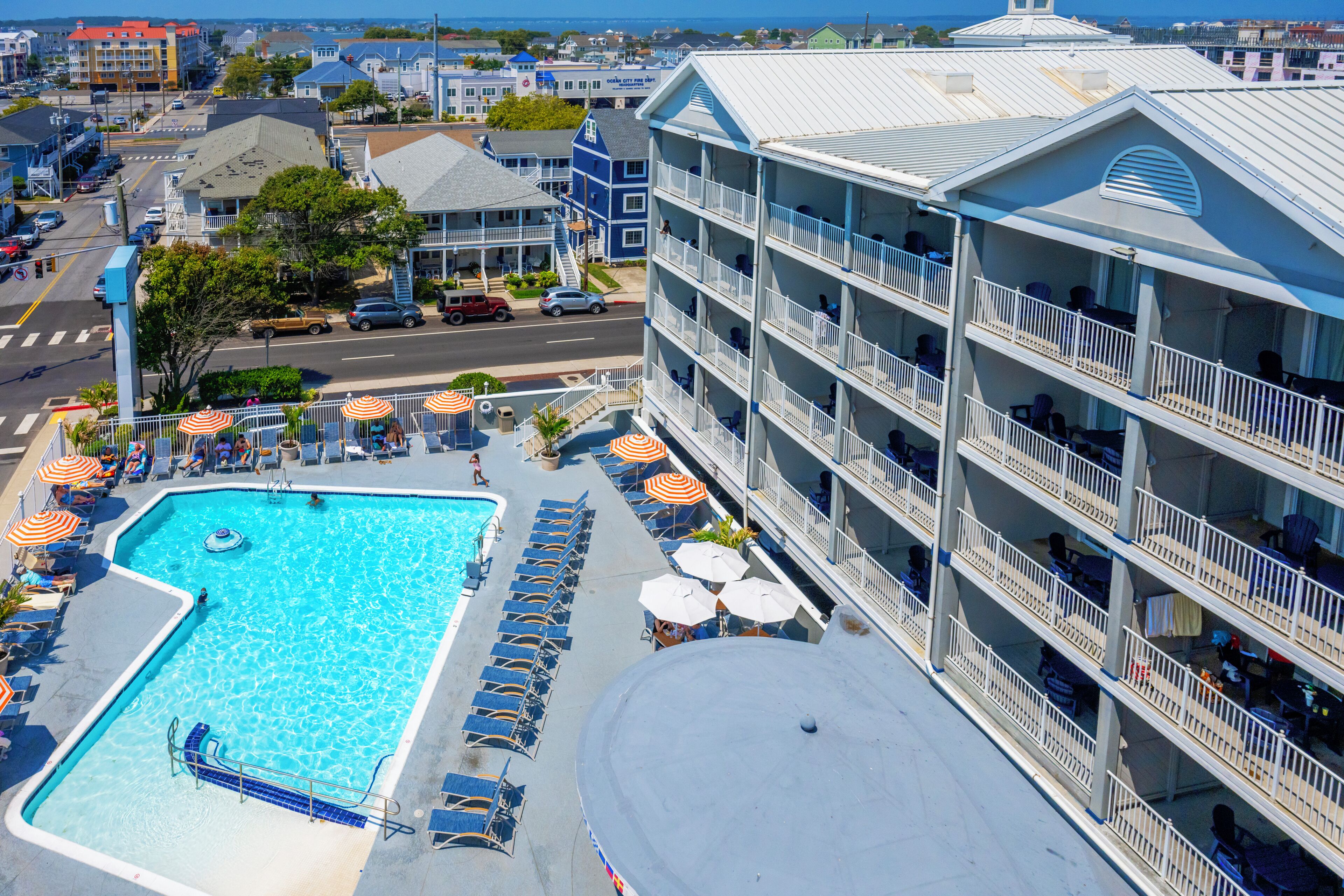 Un hotel con piscina, diversi balconi e vista sulla campagna circostante.
