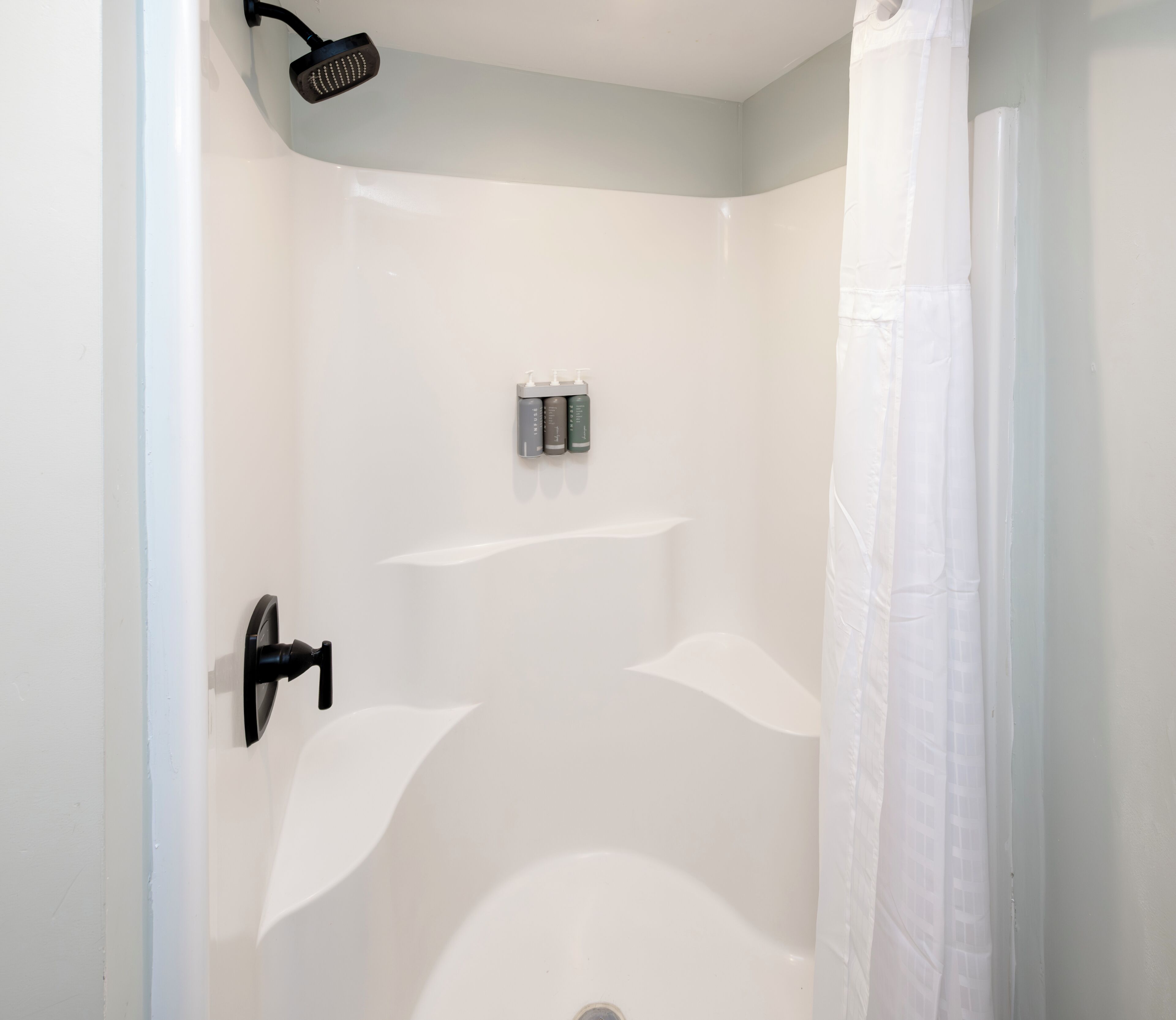 A modern bathroom with a shower, a toilet, and a sink.