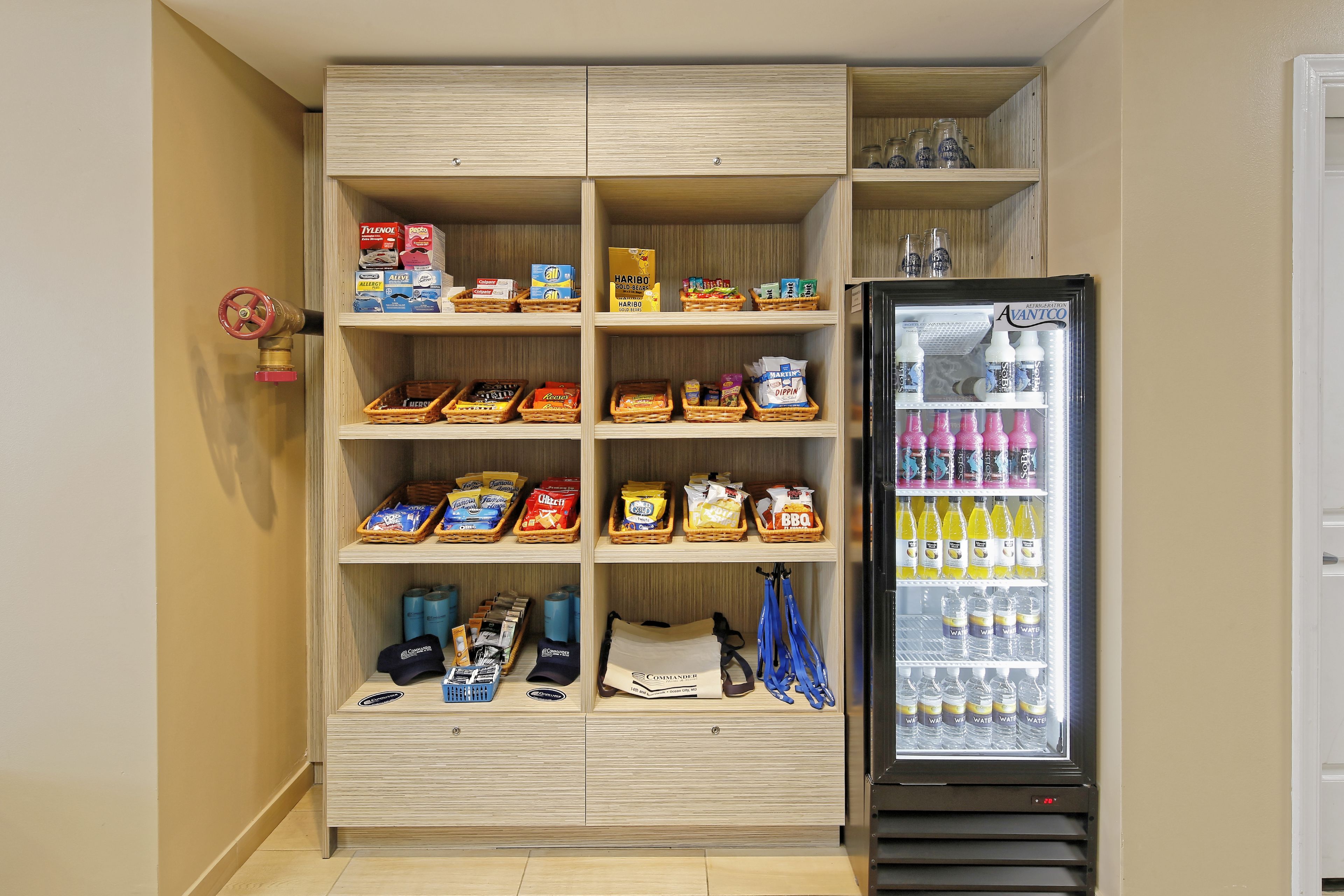 Um depósito com prateleiras contendo lanches, água engarrafada e outros objetos.
