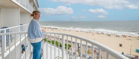 A balcony with a view of a beach and ocean.